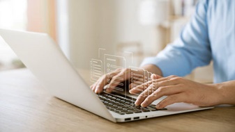 Imagen con fines ilustrativos de una computadora en un escritorio con unas manos en el teclado. 