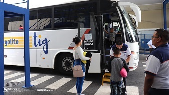 Bus de TIG en terminal con pasajeros abordando