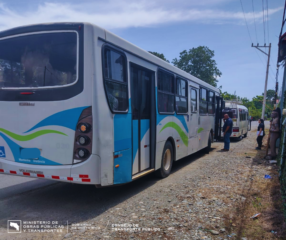 Autobús estacionado en carretera siendo inspeccionado.